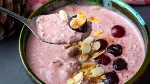 Delicious Overnight Cherry Oats in a glass jar with fresh cherries on top