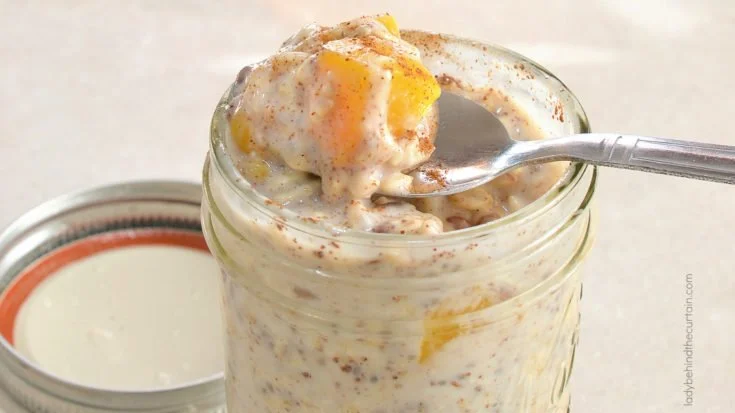 Bowl of Overnight Peach Cobbler Oatmeal topped with fresh peaches and cinnamon