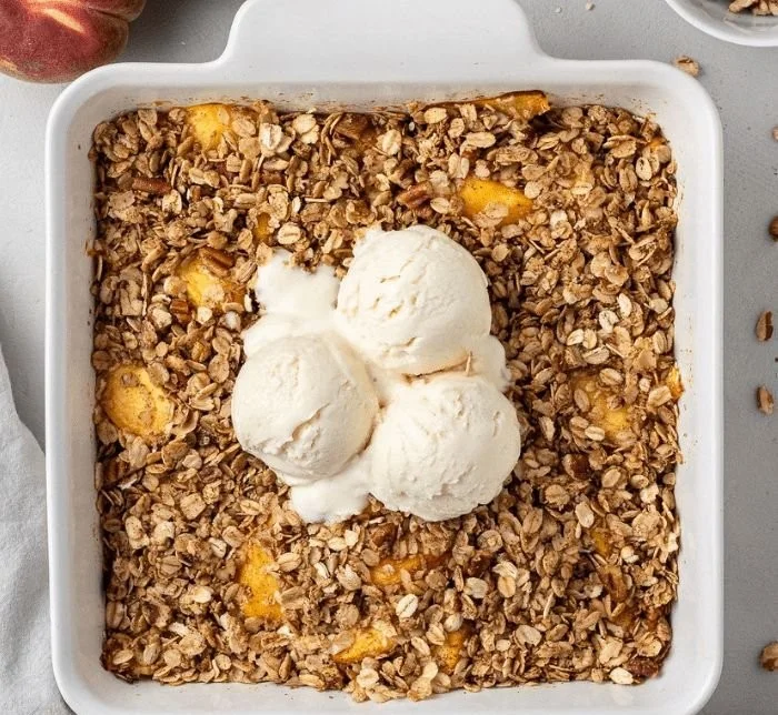 Delicious homemade Peach Crisp with a golden topping and fresh peaches