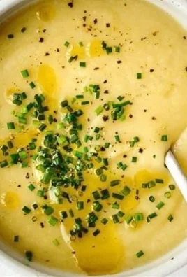 Bowl of creamy Potato Leek Soup garnished with fresh herbs