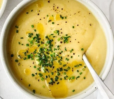 Bowl of creamy Potato Leek Soup garnished with fresh herbs