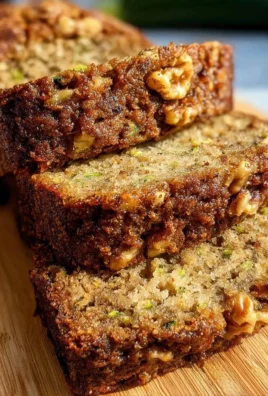Slice of moist homemade zucchini bread on a wooden table